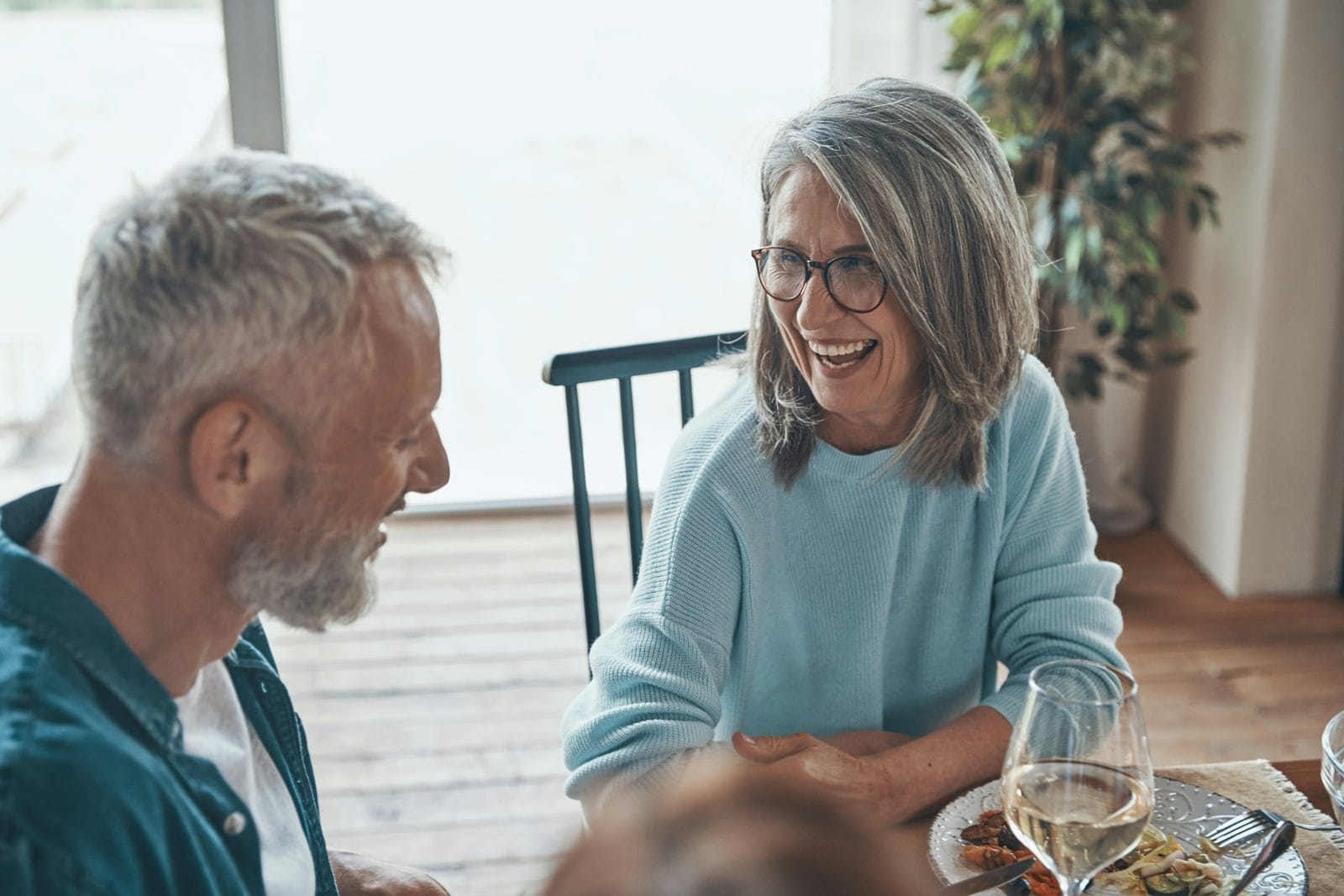 A couple laughing together across a table A couple laughing together across a table