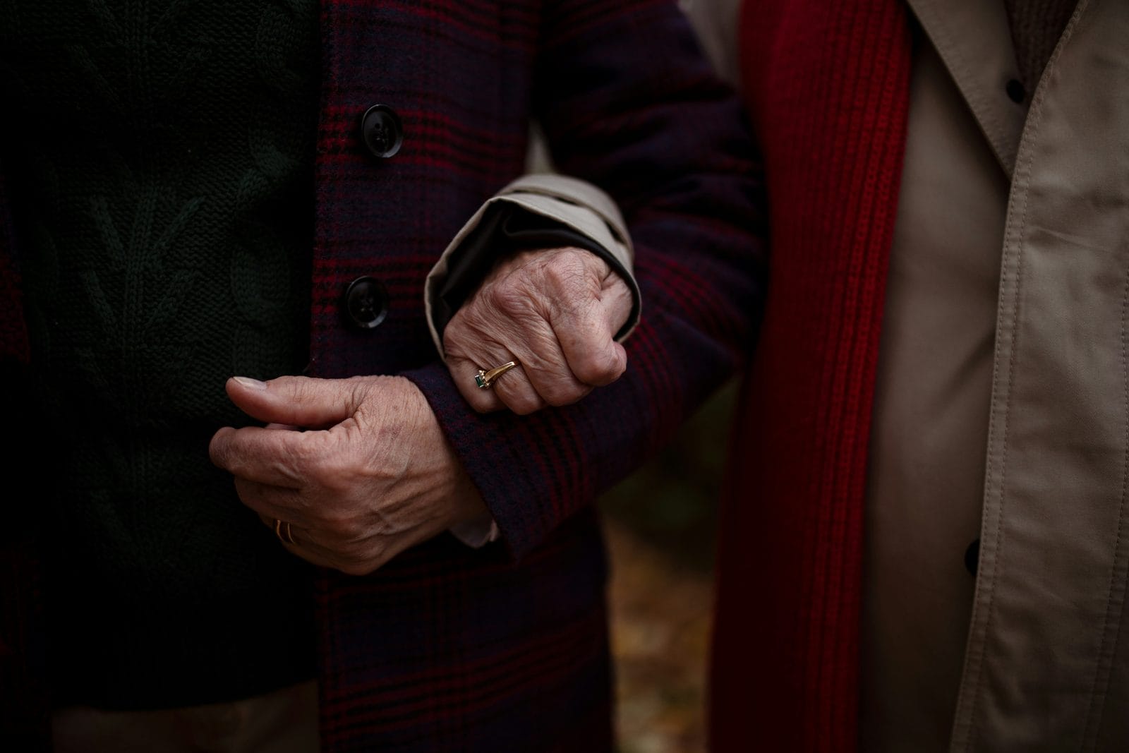 A close view of two people walking arm in arm, faces not visible