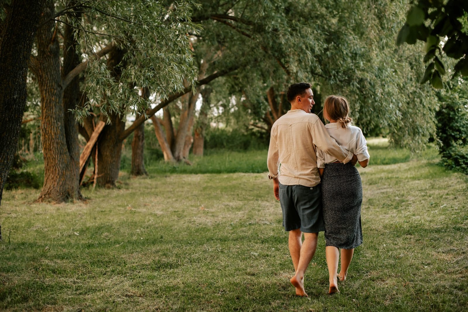 A man and a woman walking together through a park A man and a woman walking together through a park