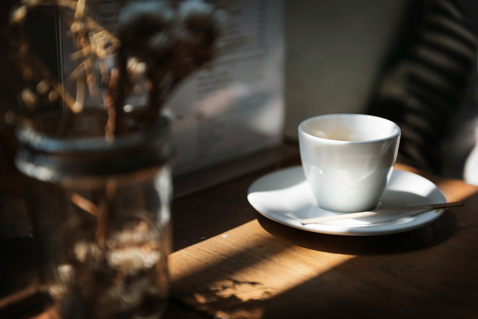 A cup of coffee on a table in warm window light