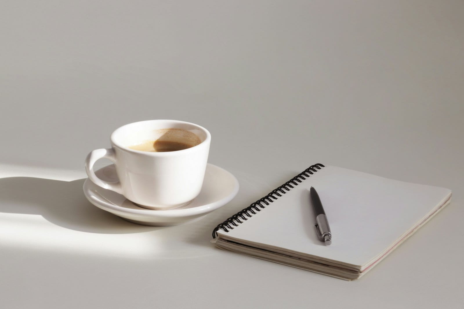 An open notebook and a cup of coffee on a table