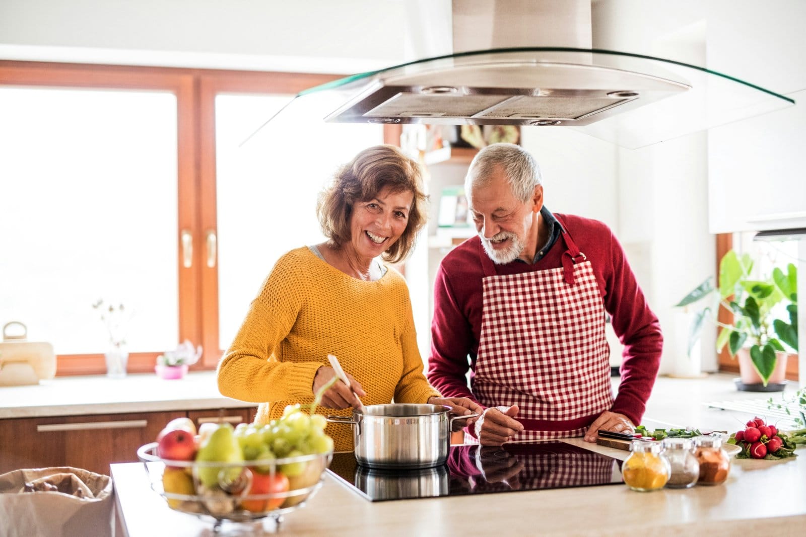 An older couple preparing food together in a home kitchen