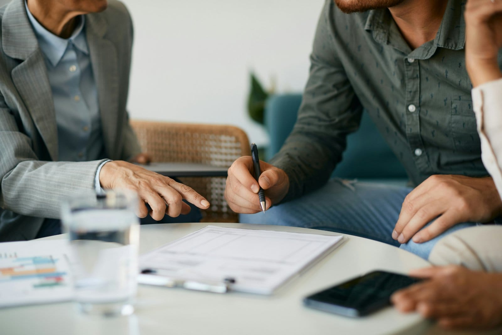 A couple reviewing paperwork with an adviser across a desk