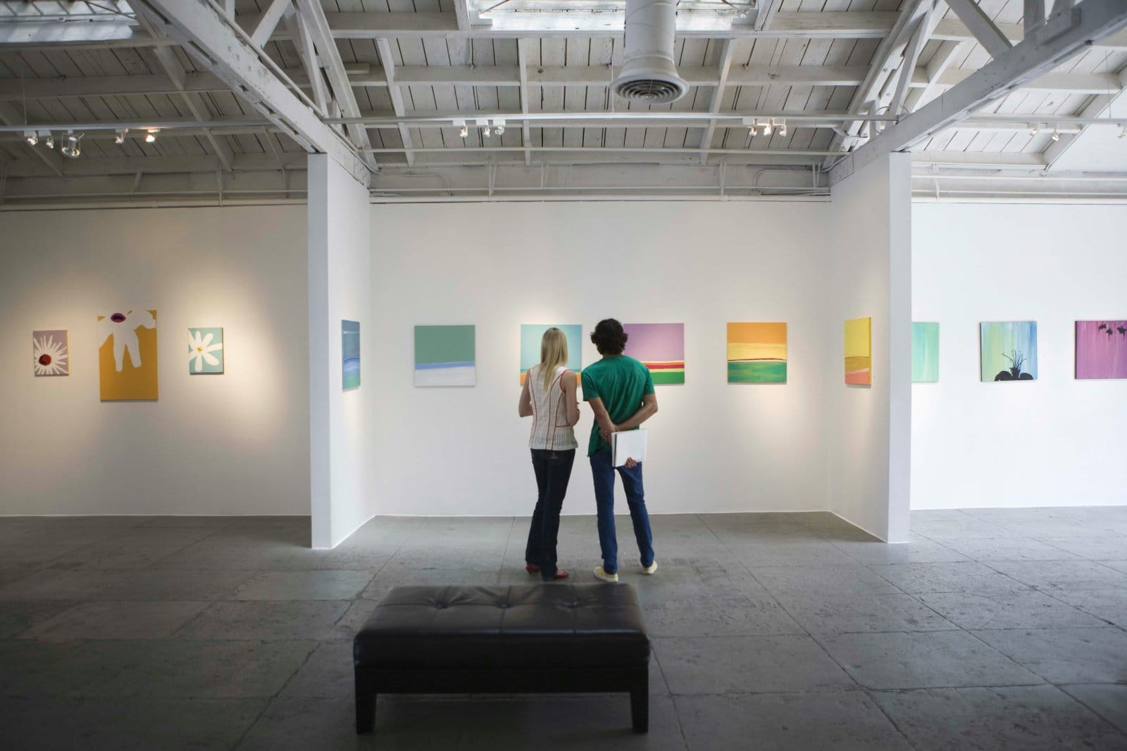 Two people looking at artwork in a gallery