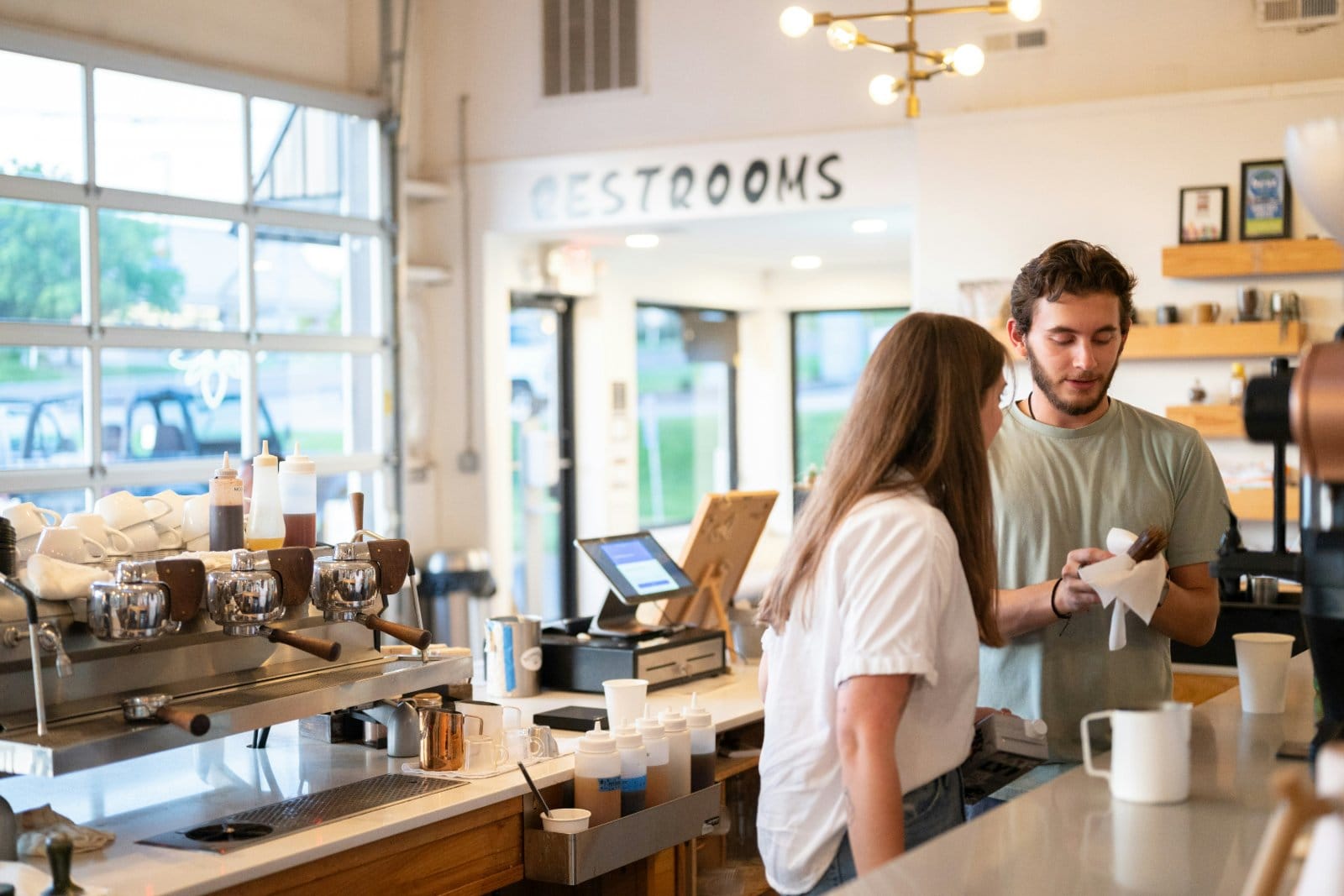 Two people in conversation at a coffee shop counter