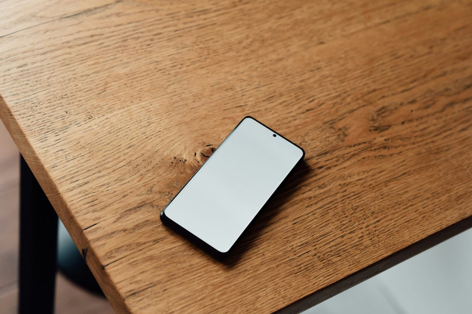 A phone resting on a wooden table